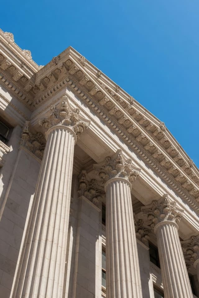 Stone columns of a classical American courthouse rising against a clear sky.